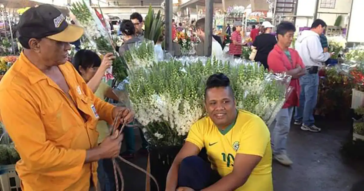 imagem de um homem vendendo flores em uma feira